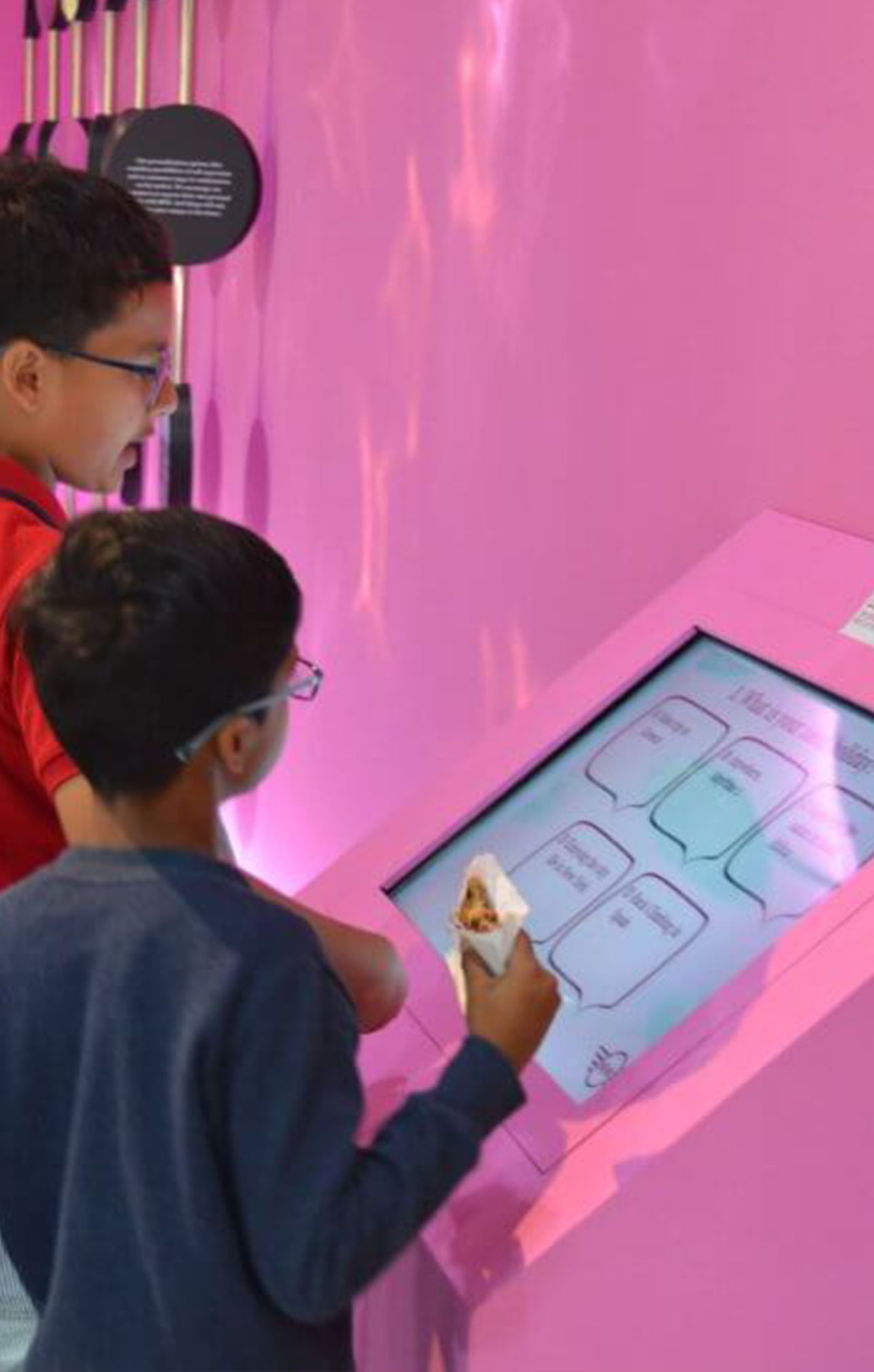 Two little boys interacting with the BMW world personality quiz kiosk