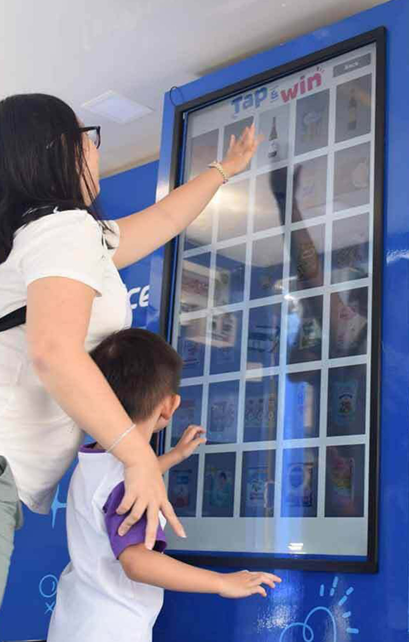 A woman and her child playing the fairprice on tap and win game