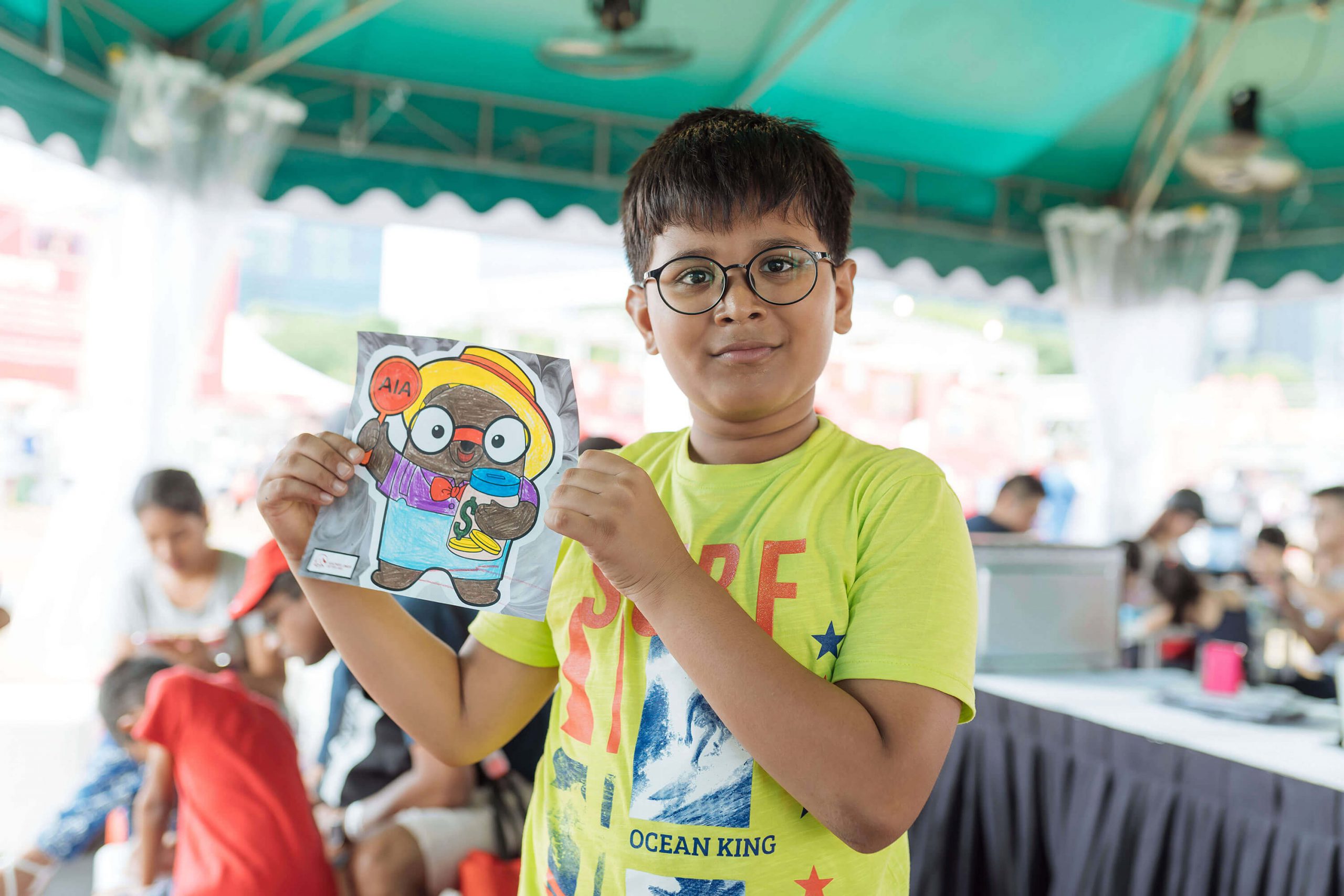 A little boy poses with his art work at the AIA Family Fest