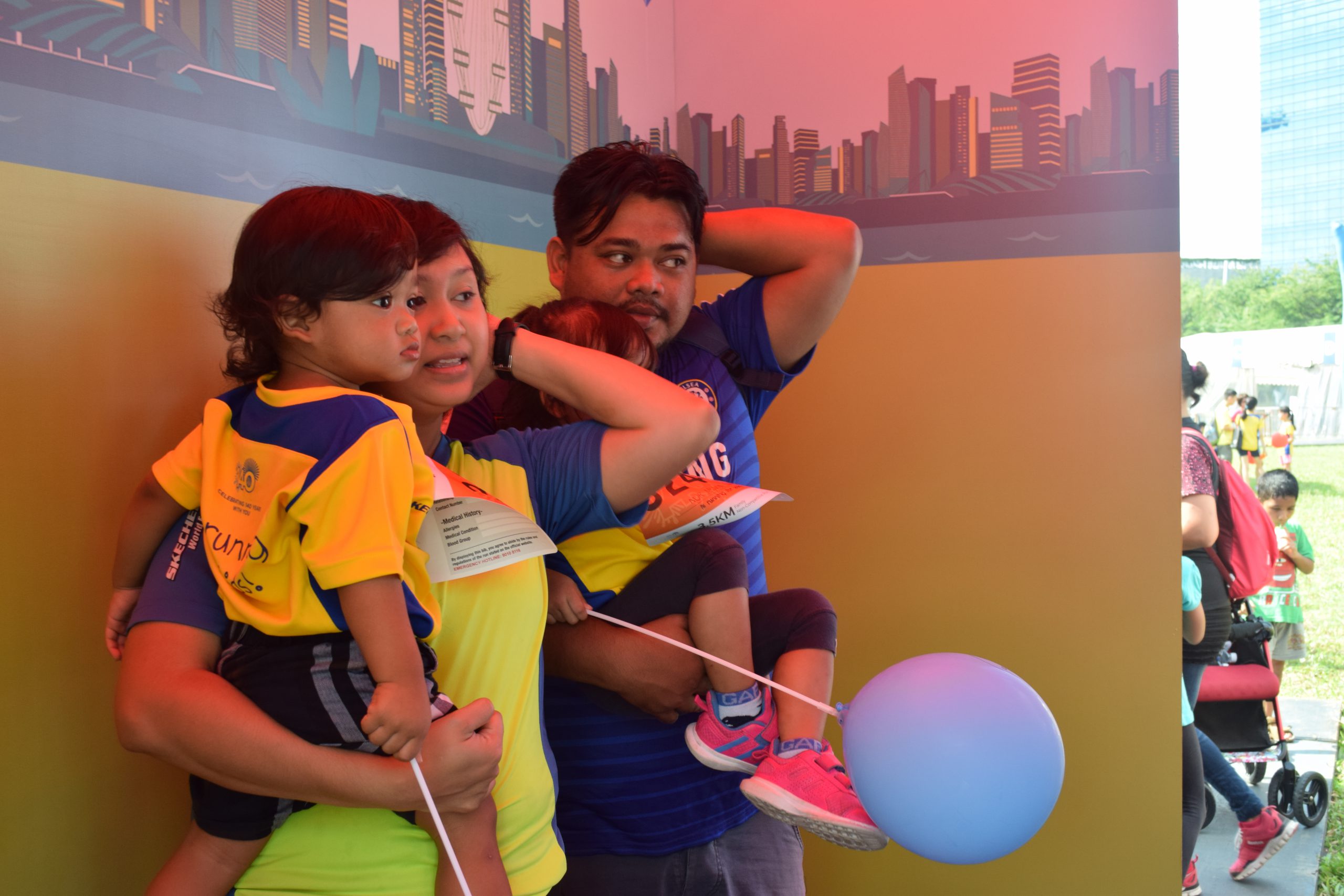 Parents with two young kids posing for the POSB Passion Run for Kids AR Photobooth