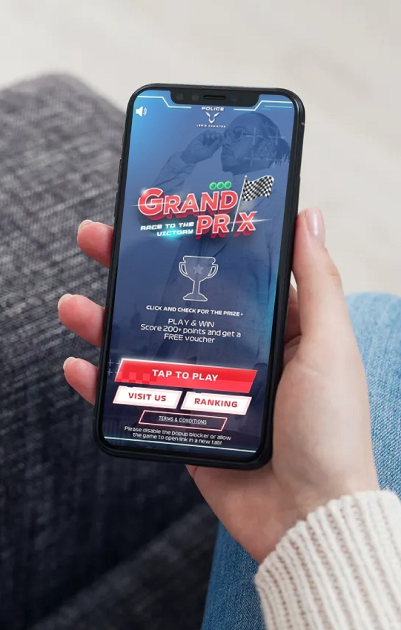 Woman in beige sweater playing the Police Lewis Hamilton Grand Prix microsite game on her smartphone